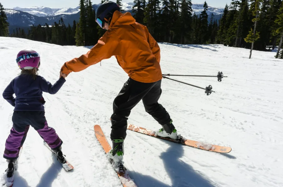 Une monitrice apprend à skier à un enfant