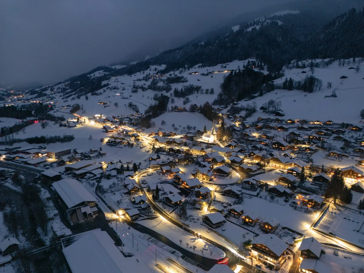 Village de montagne enneigé illuminé à la tombée de la nuit
